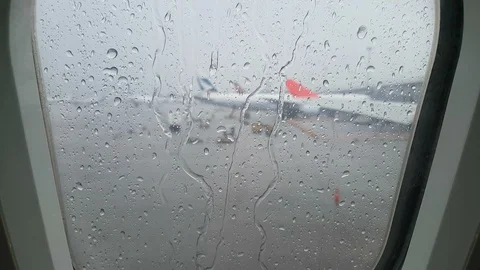Rain pours down an airplane window, bad weather at Hong Kong airport Stock-Footage 99013792