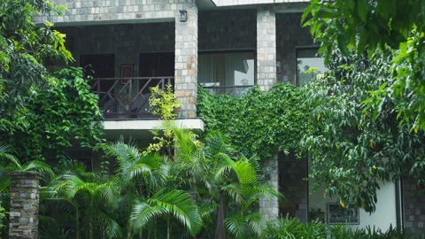 Rain pours down on a villa nestled within the jungle, a luxurious resort Stock Footage 269972864