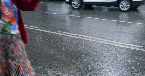 Rain pours on the paved road. Rain floods the city streets. Raindrops fall. Stock Footage 207018805
