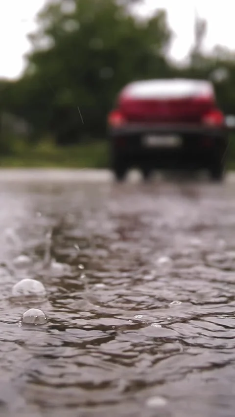 Rain, puddles. raining on parking lot. close-up. raindrops fall into puddles Stock Footage 309685712
