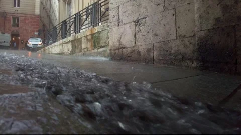 Rain river waterflow down on a street into the city Video stock 243823806