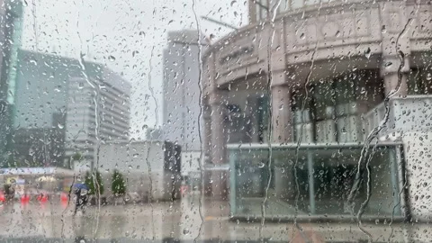 Rain Running down on a Big Window with 2 people pass walking at Sapporo City Stock Footage 157848403