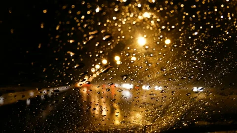 Rain running down on front car window at night with bokeh of street light Stock Footage 135508962