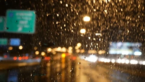 Rain running down on front car window at night Stock Footage 303390549
