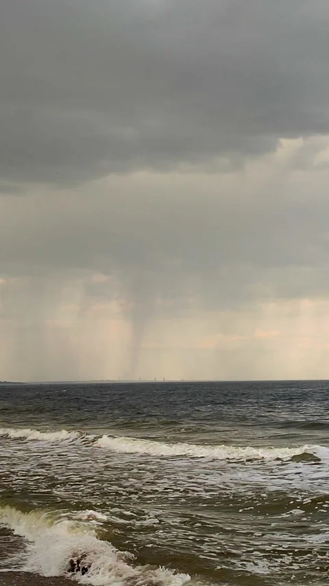 Rain on the sea. Rain streams and flows sea surface in cloudy weather Vertical Stock Footage 284466124