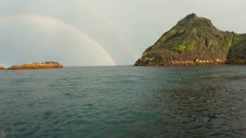 Rain on the sea surface with a rainbow background in the sky Stock Footage 133023304