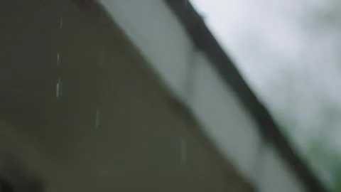 Rain shows in the foreground of a blurred building in the background Vídeos de archivo 251225966
