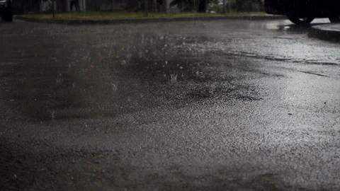 Rain in slow motion into a dark puddle on the asphalt Stock Footage 133036745