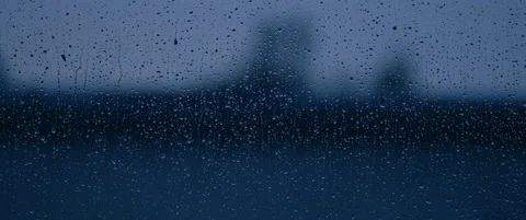 Rain slowly drips down dusky blue window Video stock 136392511