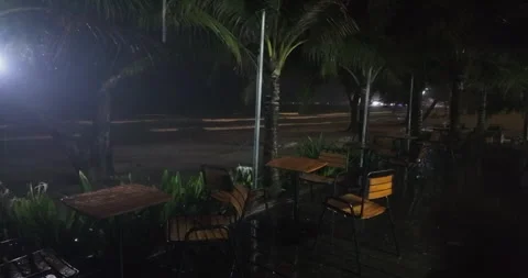 Rain soaked terrace, empty tables, dark windy beach. Stock Footage 338146965