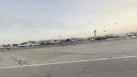 Rain-soaked window blurs the LAX control tower during takeoff Stock Footage 336220332