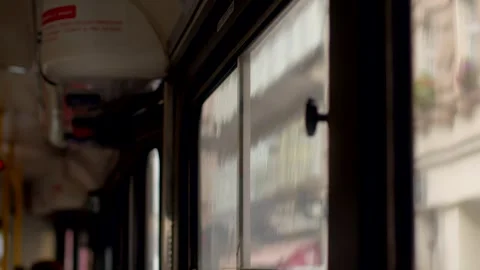 Rain-speckled tram window latch with blurred daylight city view Vidéo 347205286