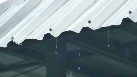 Rain splash droping from white industrial flat iron plate roof Vídeos de archivo 99503874