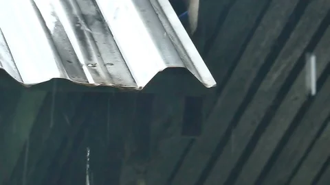 Rain splash droping from white industrial flat iron plate roof Stock Footage 99518831
