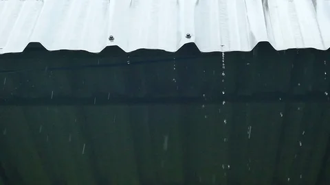 Rain splash droping from white industrial flat iron plate roof Stock Footage 99518981