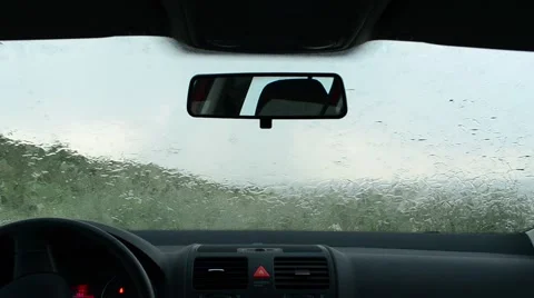 Rain splatters car windshield during severe storm, windscreen wipers cleaning wi Stock Footage 50732449