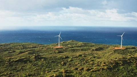 Rain starts to fall near wind turbines on a hill top spin in the wind Stock Footage 123043301