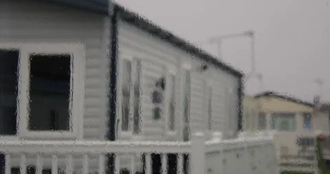 Rain on a static caravan window with static caravans in background at Stock Footage 346814950