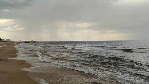 Rain storm and sandy beach shore at sea. Dark storm clouds, rain, sea surface Stock Footage 305776703