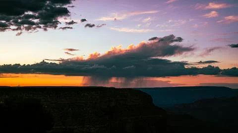 Rain storm from dark cloud above grand canyon national park at sunset in colo 스톡 사진