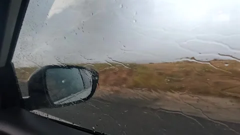 Rain streaking across a car side window in close view during travel in Turkey Stock Footage 343805230