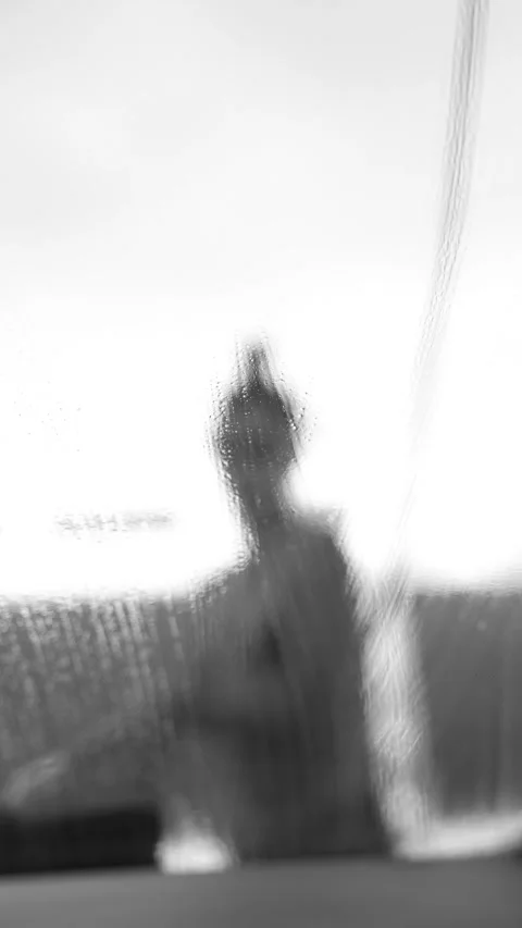 Rain streaks across a blurred windshield in bright light Stock Footage 346643601