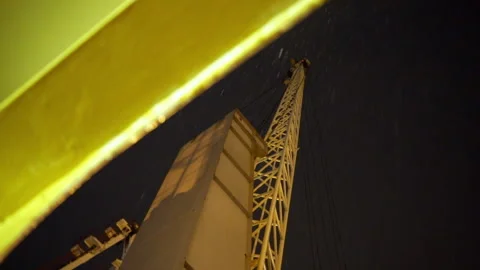 Rain streams down crane tower glowing in harsh light Stock Footage 320434598