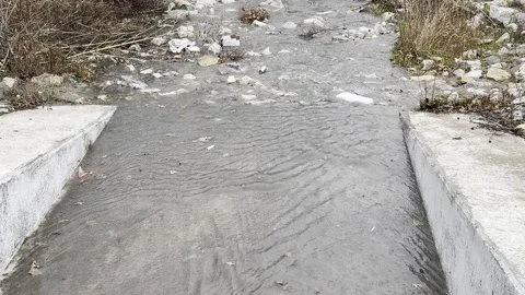 Rain Swollen Creek Flowing Through Concrete Channel Video stock 344779348