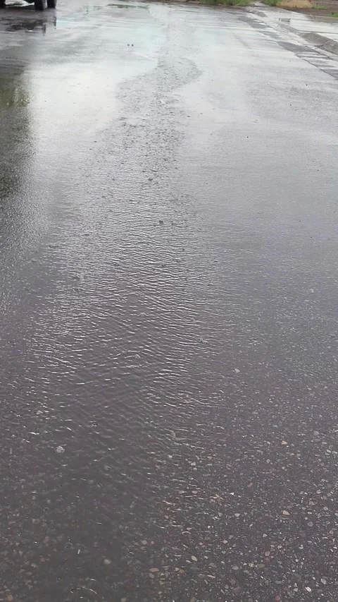 Rain taps asphalt, creating ripples as the water streams down street. Vidéo 339642047