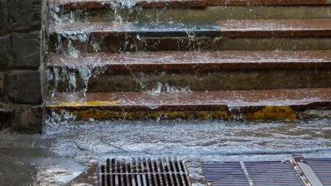 Rain water cascades down the steps into swewrage Foto stock