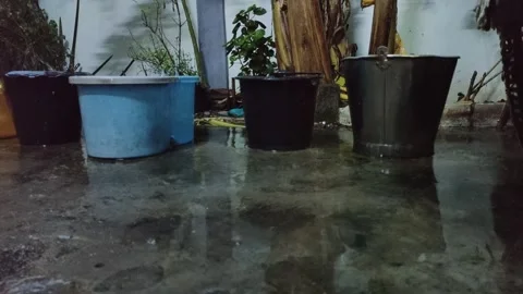 Rain water collection buckets in backyard during rain Stock Footage 347928717
