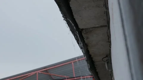 Rain Water Dripping from Gutter Edge of Concrete Building in Winter Stock Footage 335638574