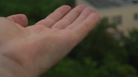 Rain water drop fall on human hand with green nature in background, environmenta Stock Footage 281577148
