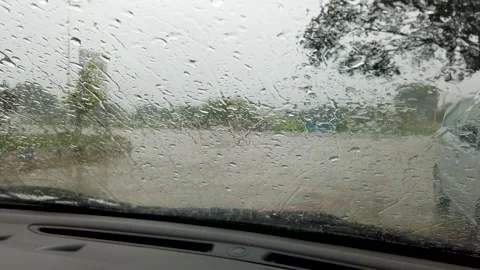 Rain water droplets falling, dripping, wet, smoggy, car windshield. Stock Footage 313850535