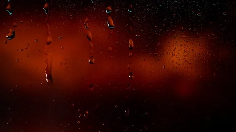 Rain water droplets trickling down the window pane against a red background Vidéo 126204073