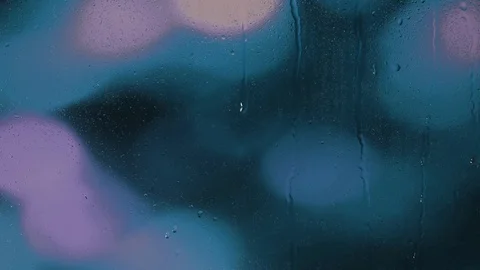 Rain water droplets trickling down the window pane against a blue background Stock Footage 126204409