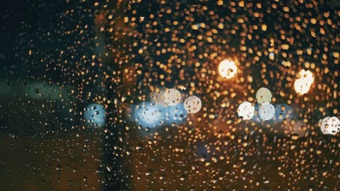 Rain Water Drops on car Window in Rainy night with Blurred Night City Traffic as Stock Footage 84762563