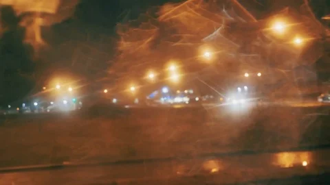 Rain Water Drops on car Window in Rainy night with Blurred Night City Traffic as Stock Footage 84762762