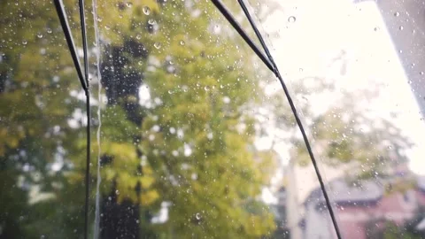 Rain water drops fall on transparent umbrella on street outdoors. Autumn weather Stock Footage 140818229