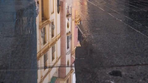 Rain water drops falling into big puddle - Reflection of a church in the puddle. Stock Footage 120281939
