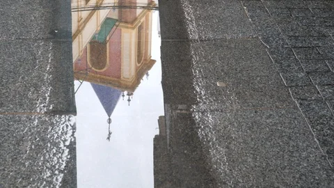 Rain water drops falling into big puddle- Reflection of a church in the puddle. Stock Footage 120283149