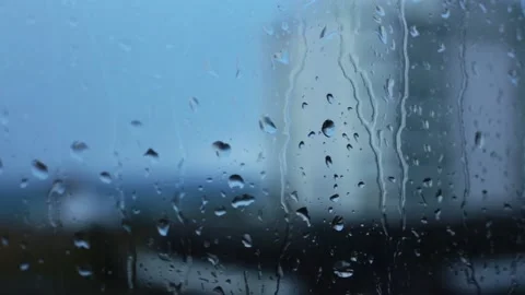 Rain water drops falling down on the window blue glass. drops on glass surface Video stock 145646321