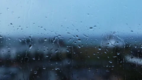 Rain water drops falling down on the window blue glass. drops on glass surface Stock Footage 145646351