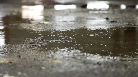 Rain water drops falling into puddle Stock Footage 232911936