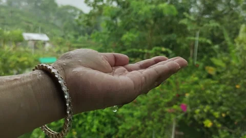 Rain water drops falling on woman's hand Stock Footage 213962624