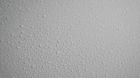 Rain water drops flow down a smooth white wall. Close up. Slow motion Stock Footage 114418528