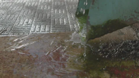 Rain water flowing down gutter and hitting the ground Stock Footage 229333420