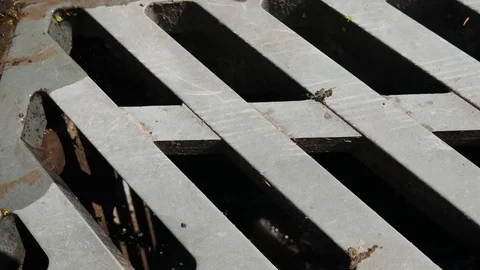 Rain water flowing into a drain.Rainwater flows on the asphalt road and fall int Stock Footage 90969367