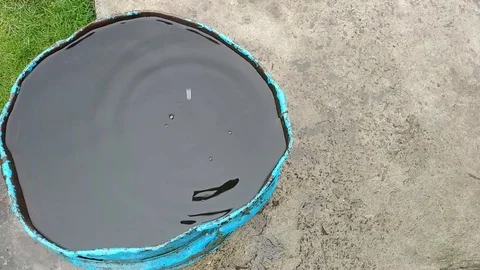 Rain water flowing into old rusty barrel top view Stock Footage 106531481