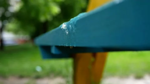 Rain water flows down a bench in a park. Spring rainy day. Stock Footage 131228141